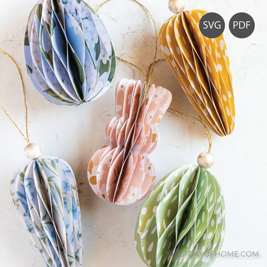 Paper Easter ornaments in the shapes of bunnies, carrots, and eggs with a honeycomb pattern.