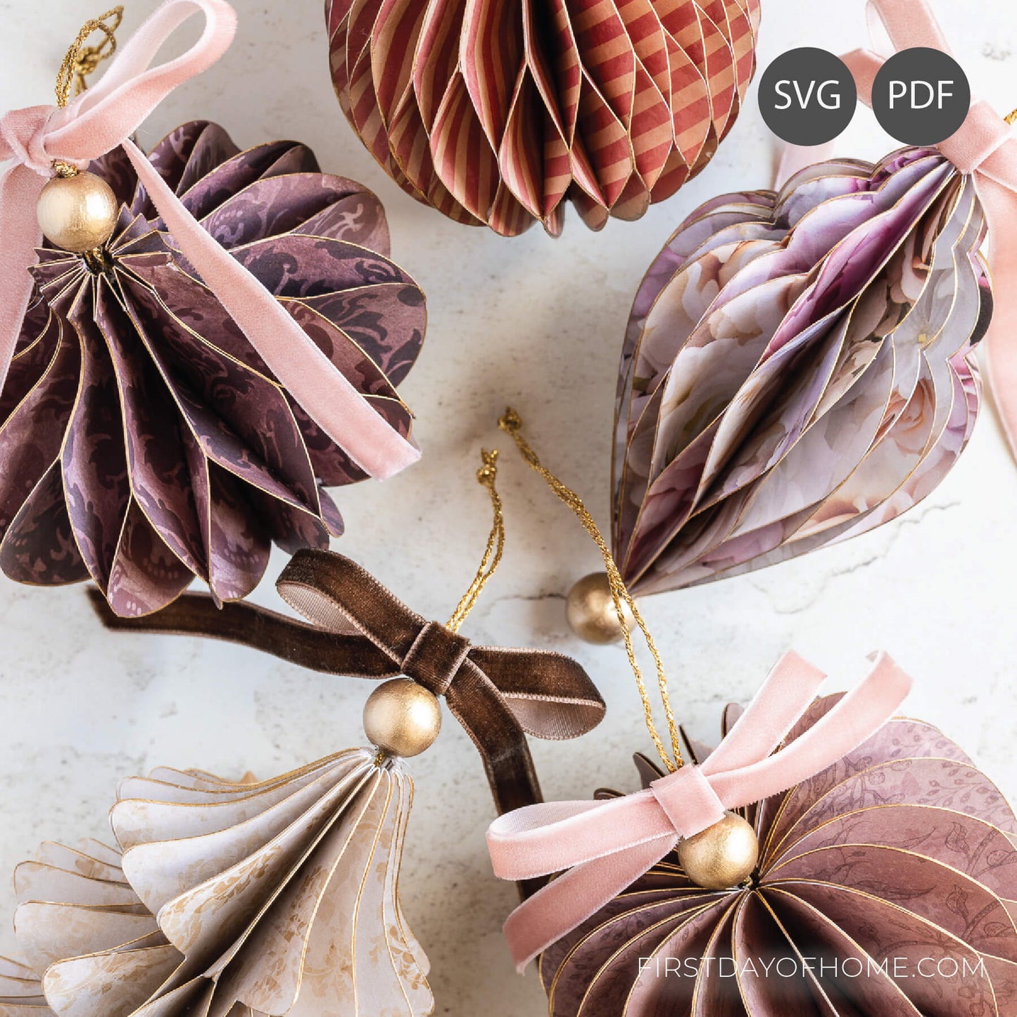 Decorative honeycomb paper ornaments with ribbons and gold balls.